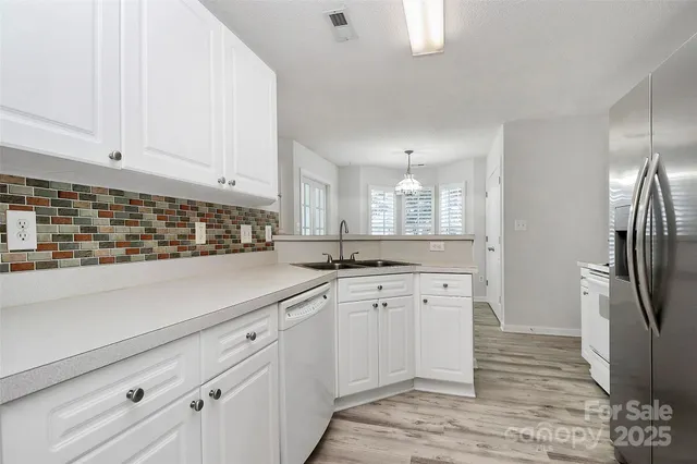 a kitchen with white cabinets and sink