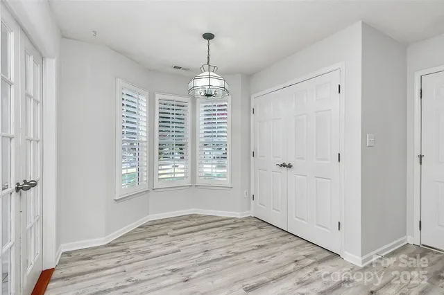 a view of empty room with window and wooden floor
