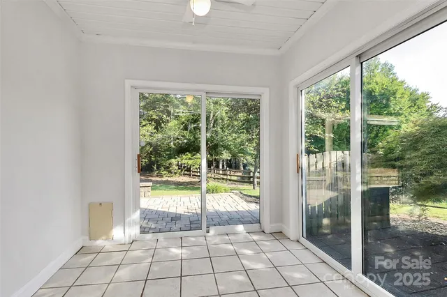 a view of an empty room and window ceiling fan