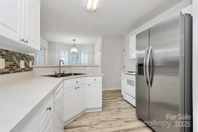 a large kitchen with cabinets a sink and stainless steel appliances