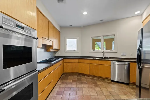 a kitchen with stainless steel appliances granite countertop a sink and a microwave