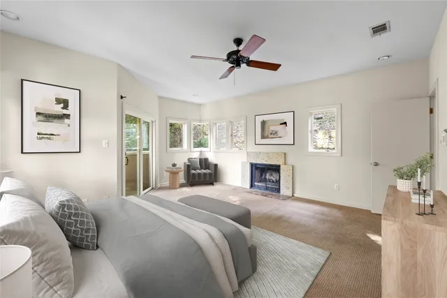 a bedroom with a bed couches and fireplace