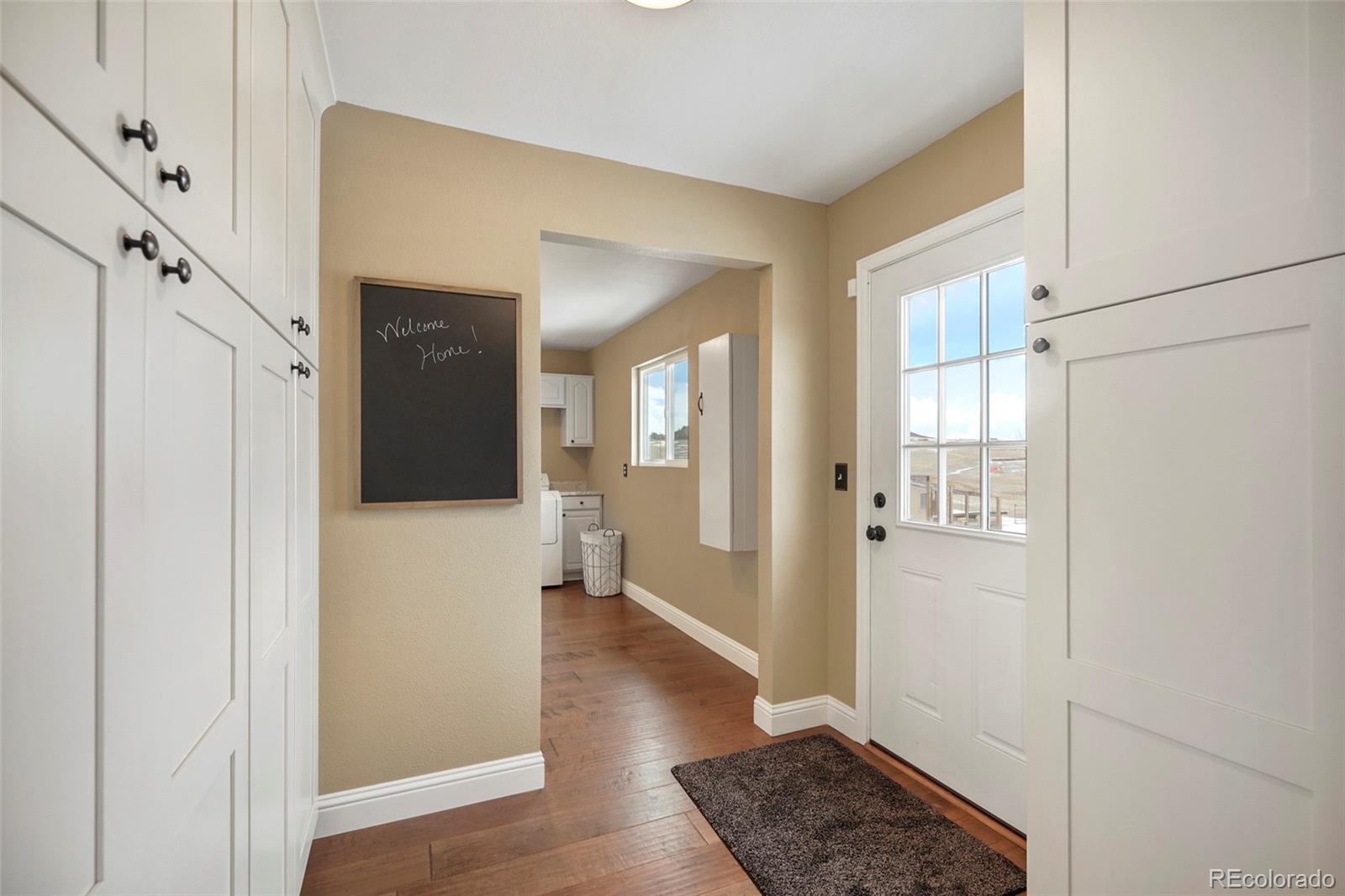 14929 South Spring Valley Road Larkspur, CO 80118 - Photo 13 of 40 a view of a hallway with wooden floor and staircase