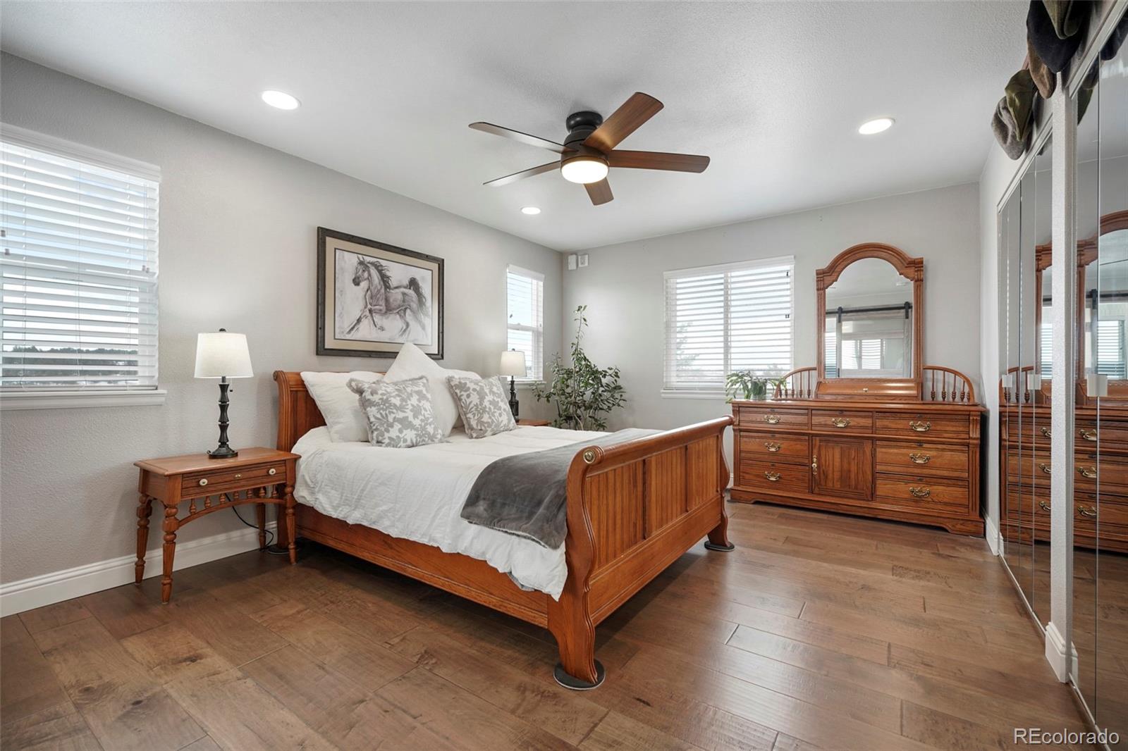 14929 South Spring Valley Road Larkspur, CO 80118 - Photo 16 of 40 a bed room with a bed and a ceiling fan