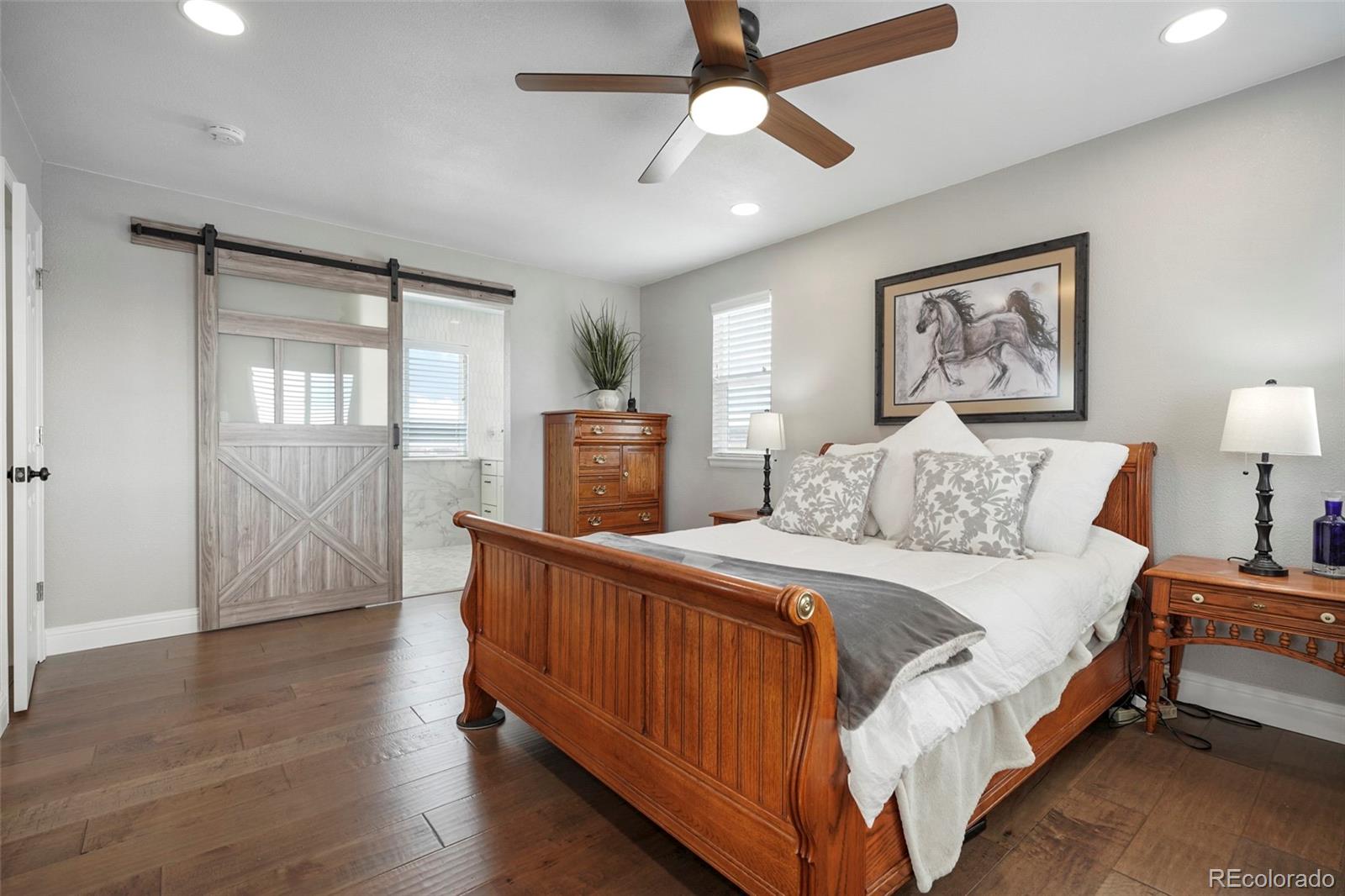 14929 South Spring Valley Road Larkspur, CO 80118 - Photo 17 of 40 a spacious bedroom with a bed and wooden floor