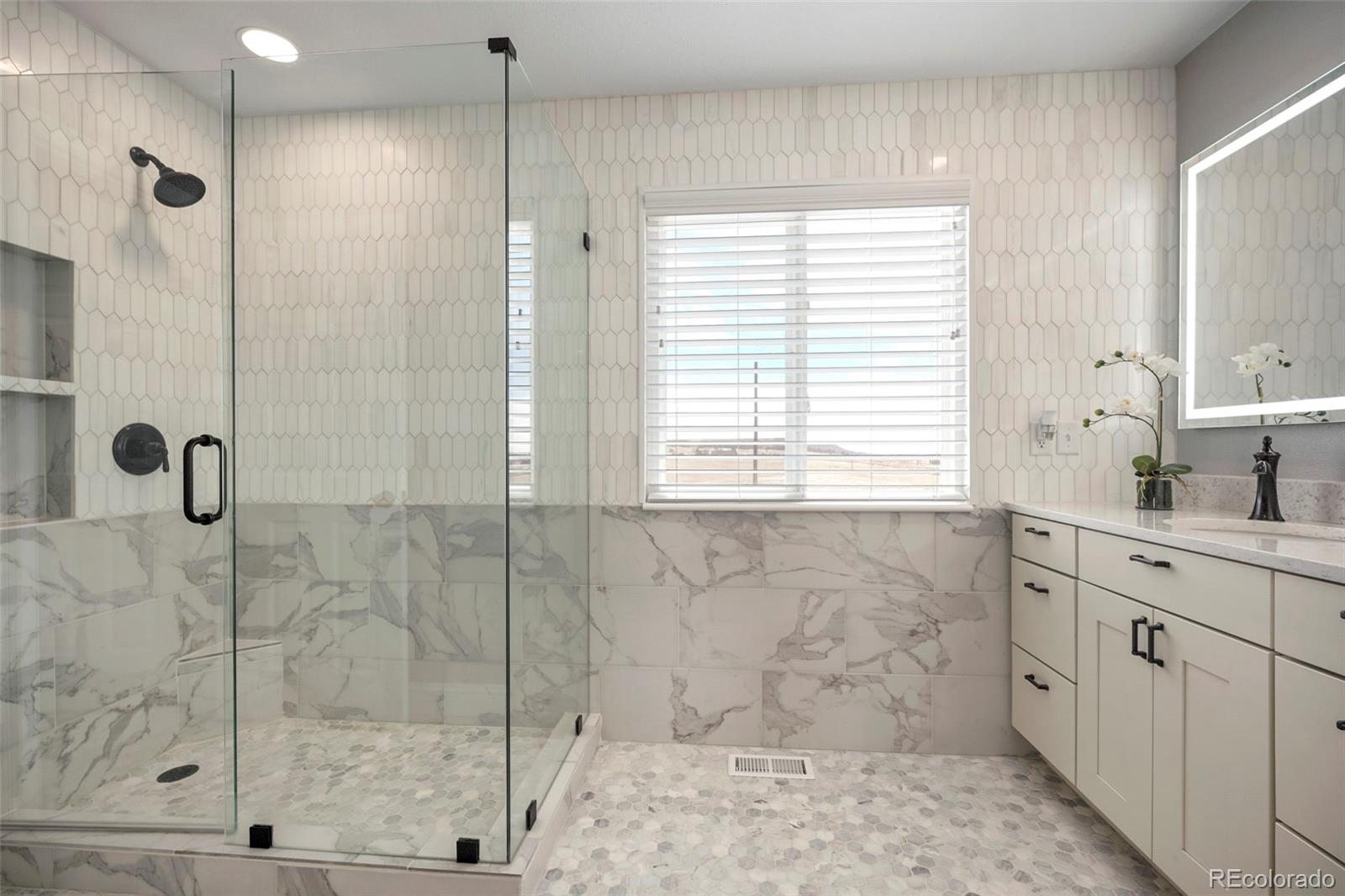 14929 South Spring Valley Road Larkspur, CO 80118 - Photo 19 of 40 a bathroom with a shower sink and mirror