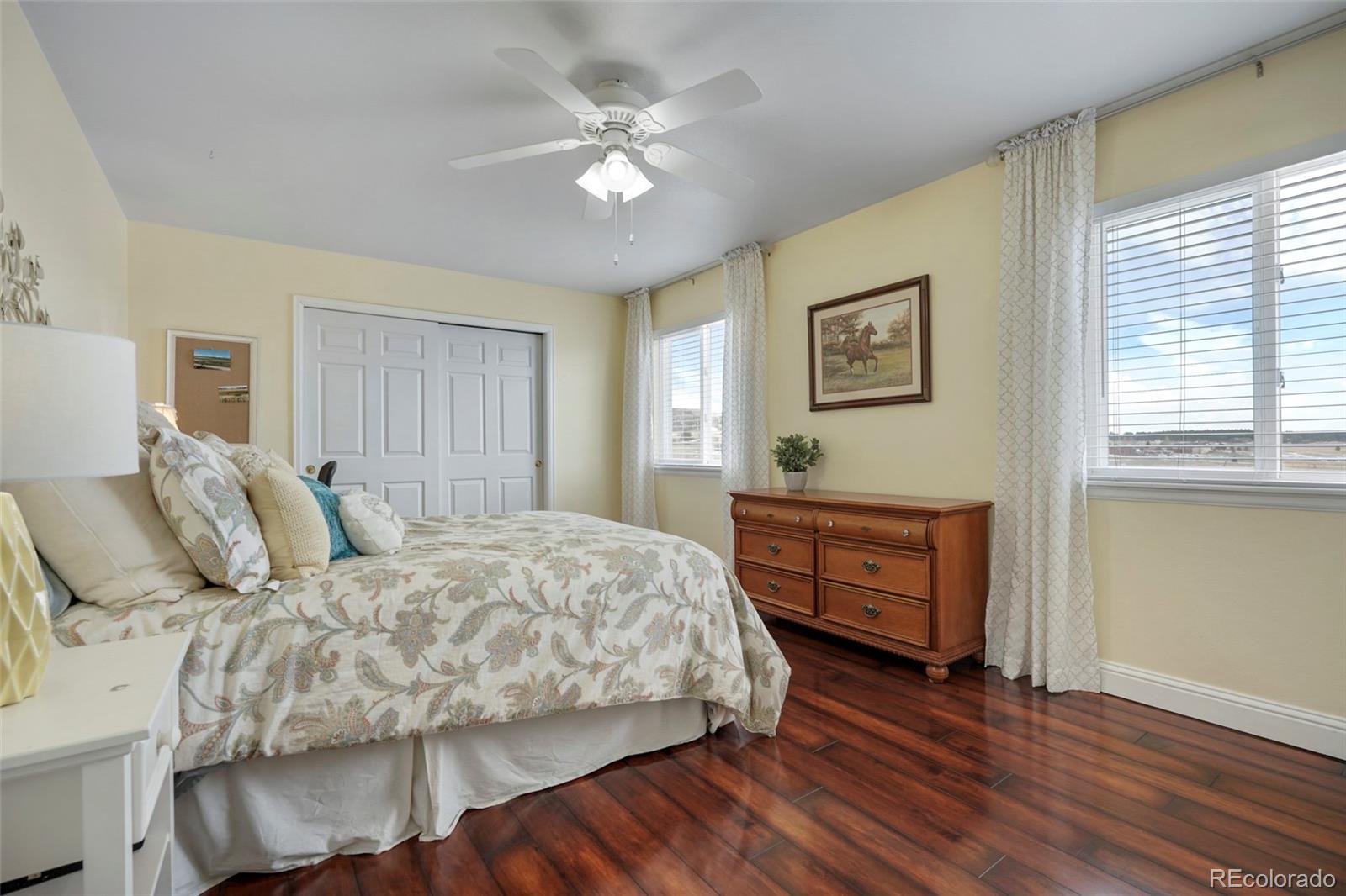 14929 South Spring Valley Road Larkspur, CO 80118 - Photo 21 of 40 a bedroom with a bed and wooden floor