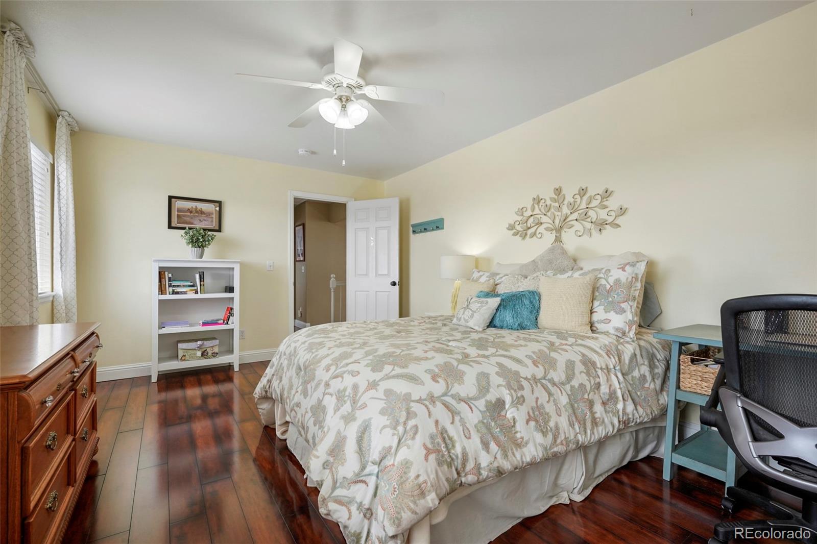 14929 South Spring Valley Road Larkspur, CO 80118 - Photo 22 of 40 a bedroom with a bed and a chandelier