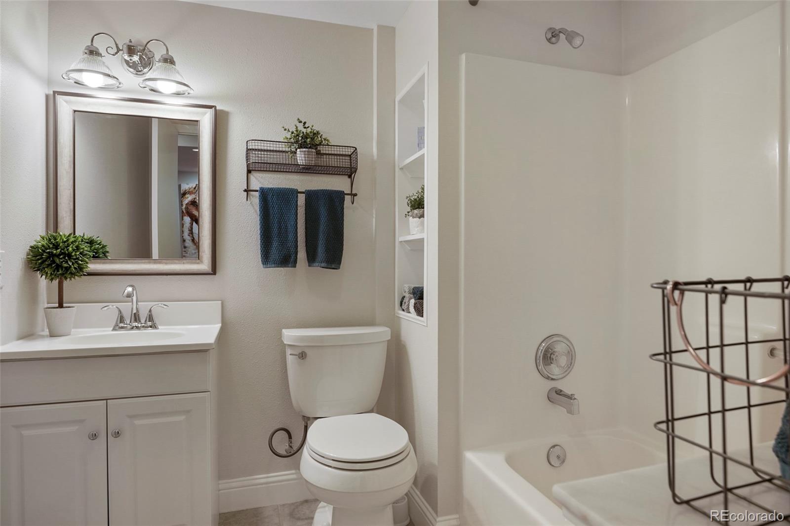 14929 South Spring Valley Road Larkspur, CO 80118 - Photo 29 of 40 a bathroom with a toilet a sink a mirror a bathtub and vanity