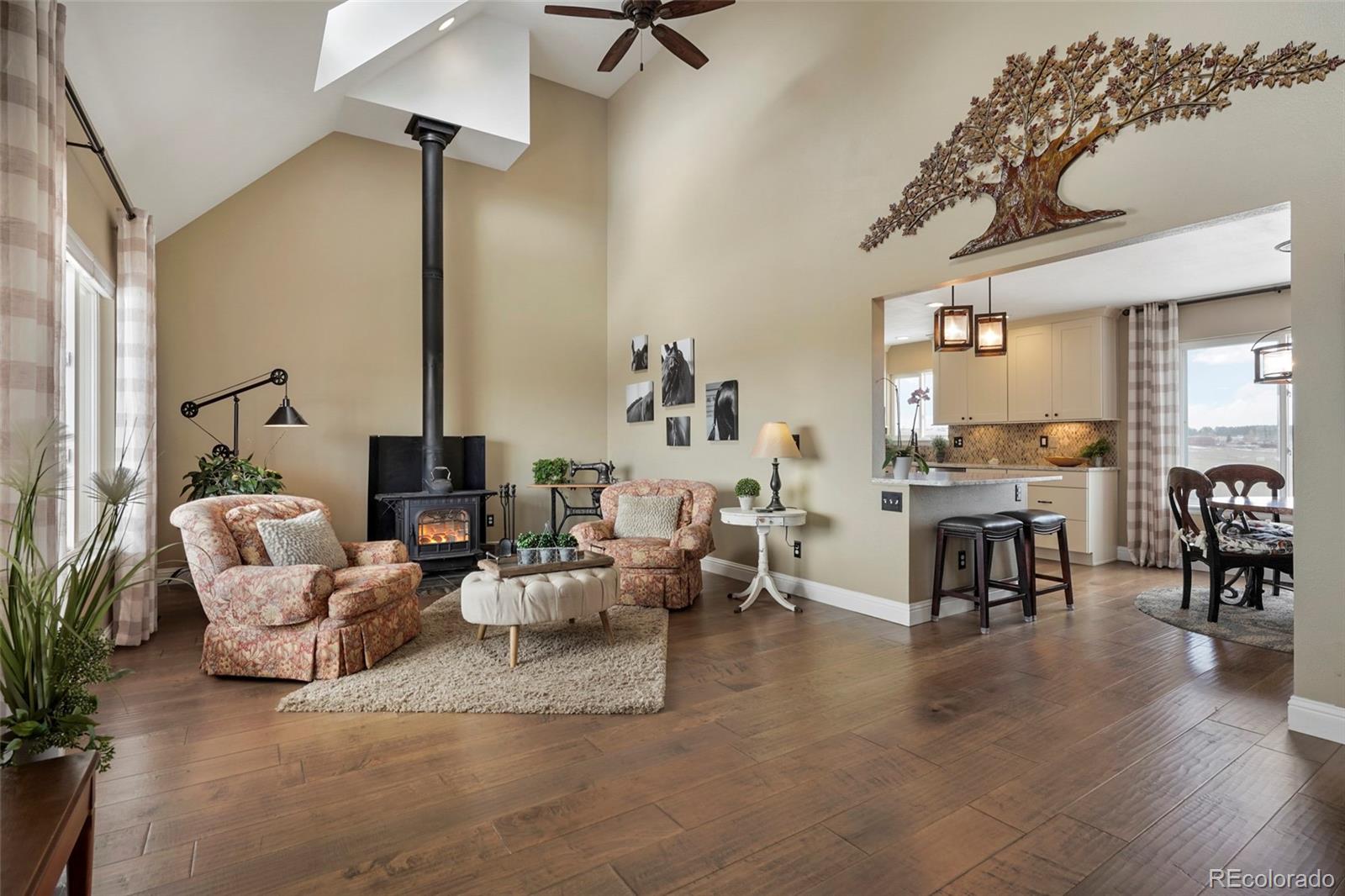 14929 South Spring Valley Road Larkspur, CO 80118 - Photo 3 of 40 a living room with fireplace furniture and a wooden floor