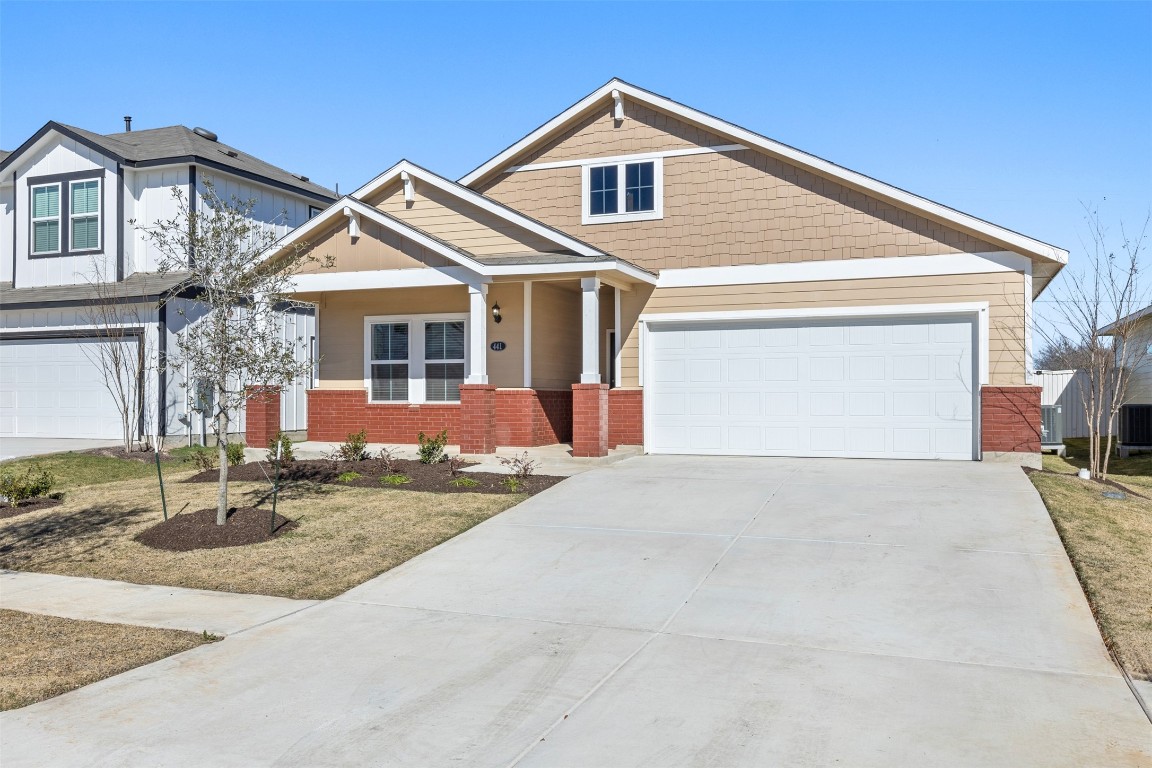 a front view of a house with garage and parking
