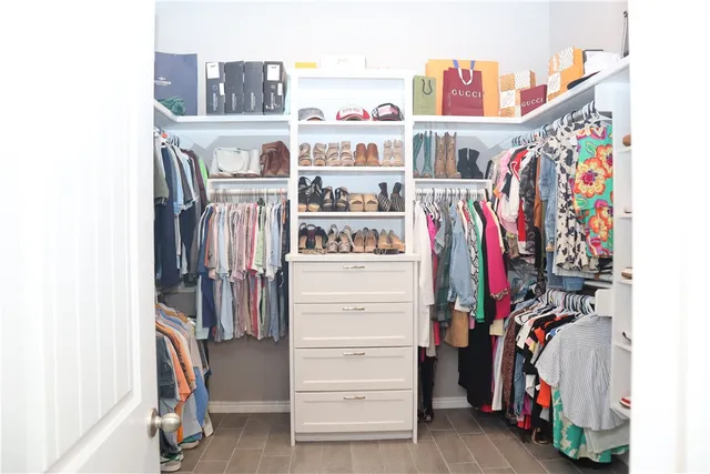 a view of walk in closet with clothes and shoes