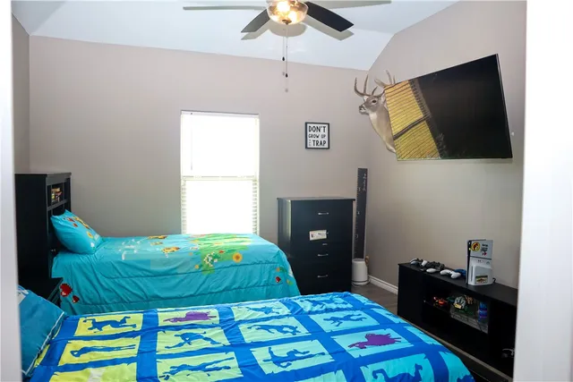 a bedroom with a bed and a flat tv screen on dresser