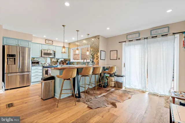 a kitchen with stainless steel appliances kitchen island granite countertop a refrigerator and a stove top oven