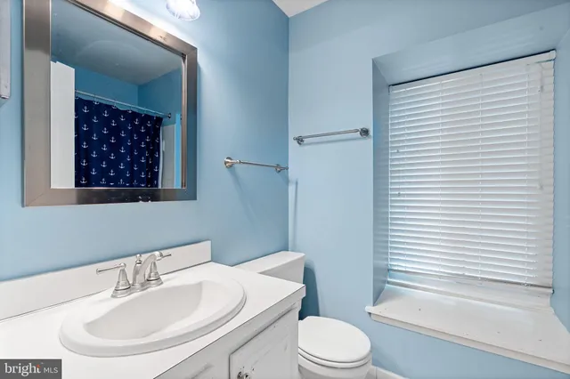 a bathroom with a sink a toilet a mirror and shower