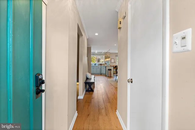 a view of a hallway with wooden floor windows and a livingroom