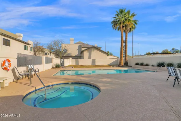 a swimming pool with a yard and palm trees