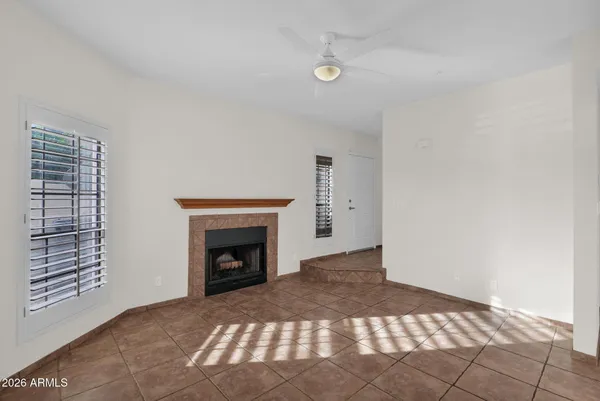 a view of an empty room with window and fire place