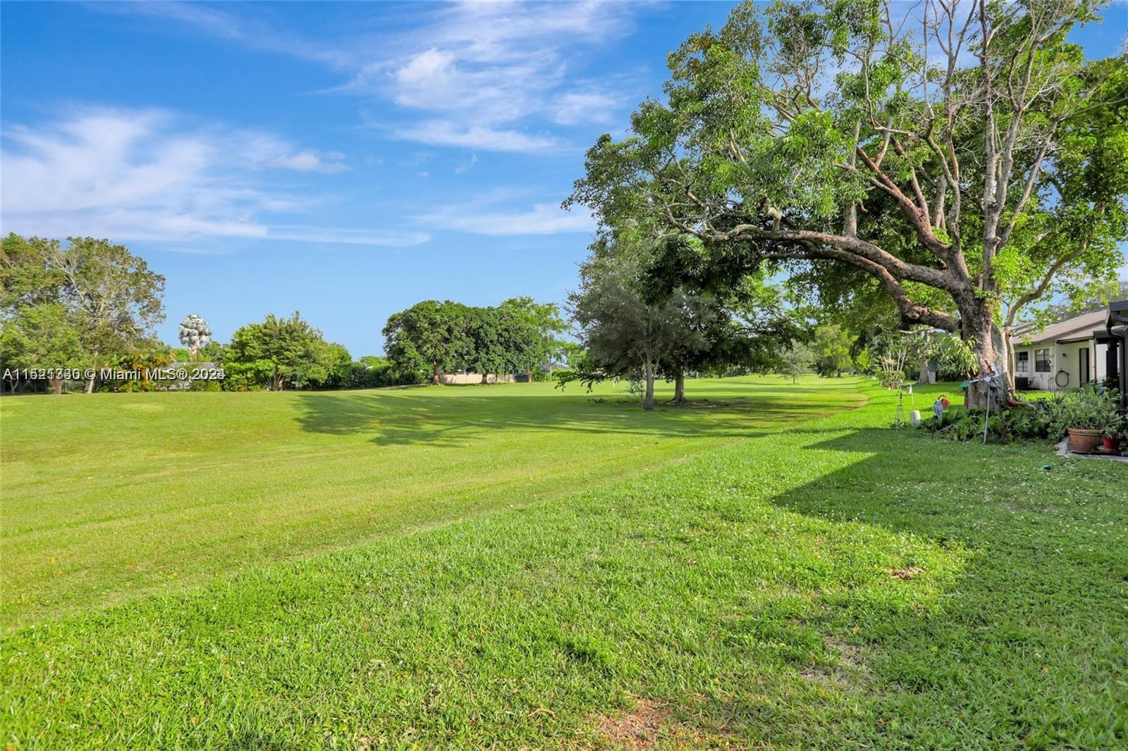6343 Pinehurst Circle, Unit D36 Tamarac, FL 33321 - Photo 11 of 13 a view of a water fountain and a big tree