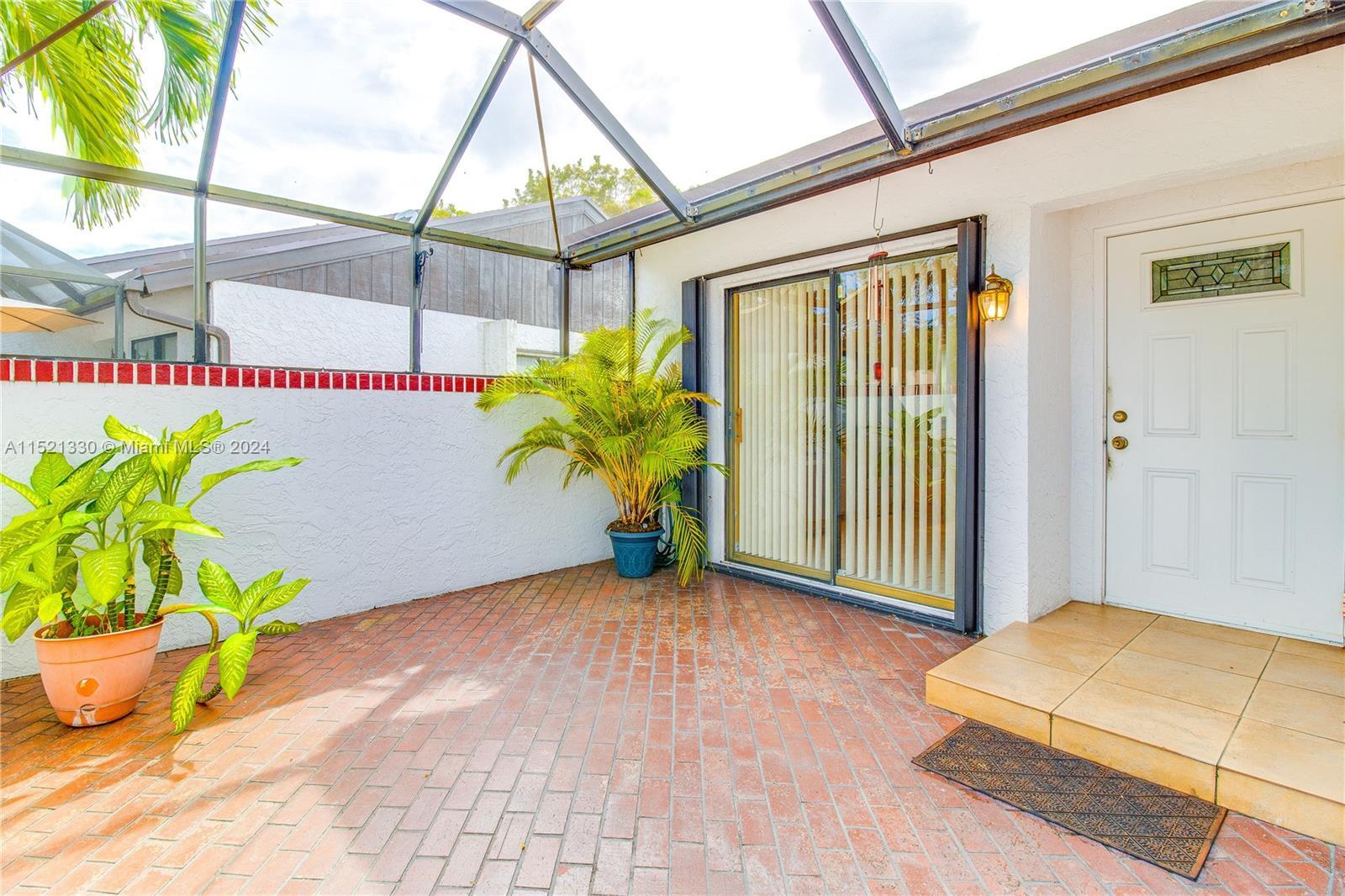 6343 Pinehurst Circle, Unit D36 Tamarac, FL 33321 - Photo 4 of 13 a porch with a table and a potted plant