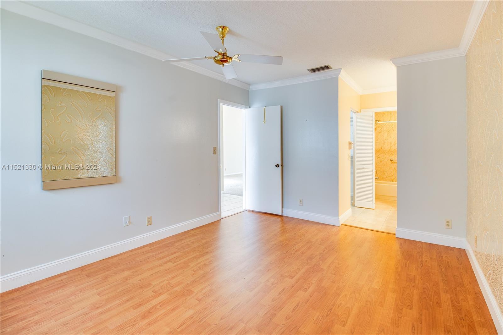 6343 Pinehurst Circle, Unit D36 Tamarac, FL 33321 - Photo 7 of 13 a view of an empty room with wooden floor and a window