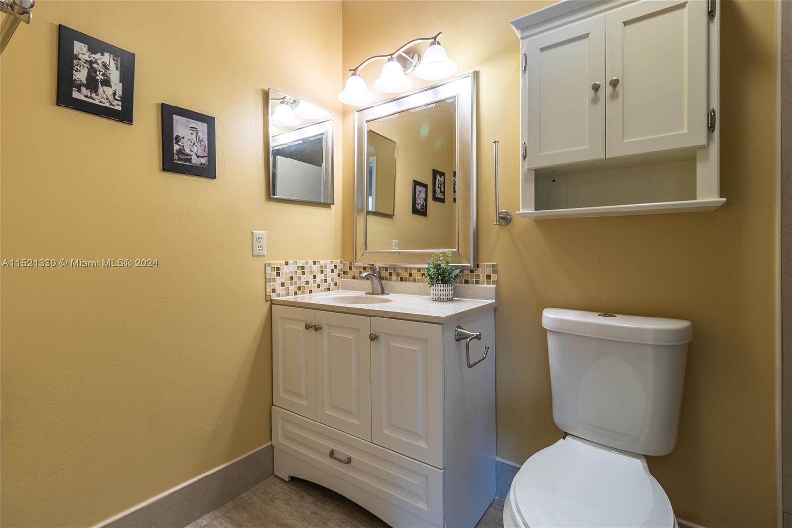 6343 Pinehurst Circle, Unit D36 Tamarac, FL 33321 - Photo 9 of 13 a bathroom with a toilet a sink and mirror