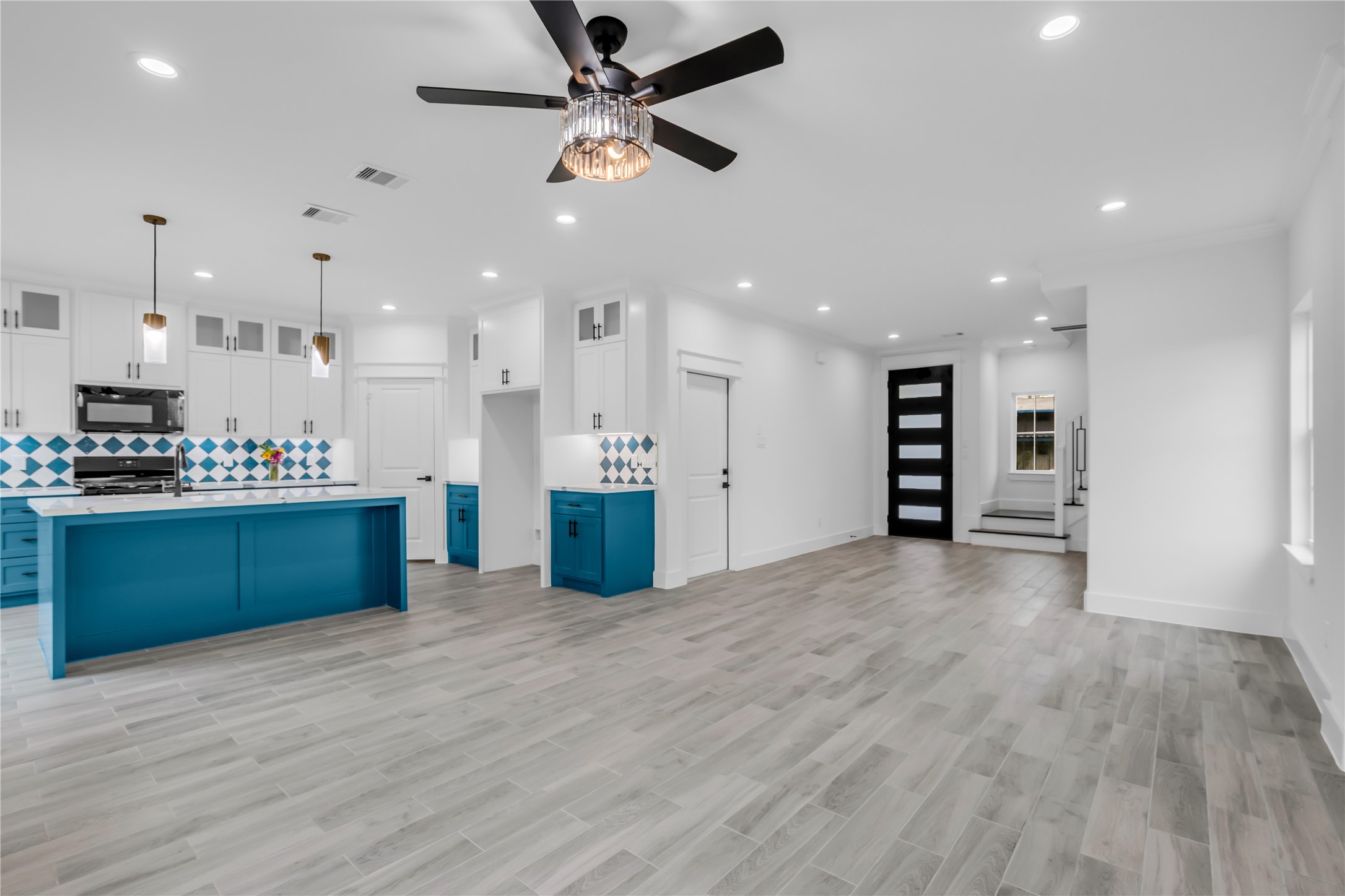 3168 Golfcrest Houston, TX 77087 - Photo 7 of 30 This open-concept living space seamlessly merges a modern kitchen featuring bold blue accents and sleek cabinetry with a spacious living and dining area, perfect for stylish entertaining and relaxed living.