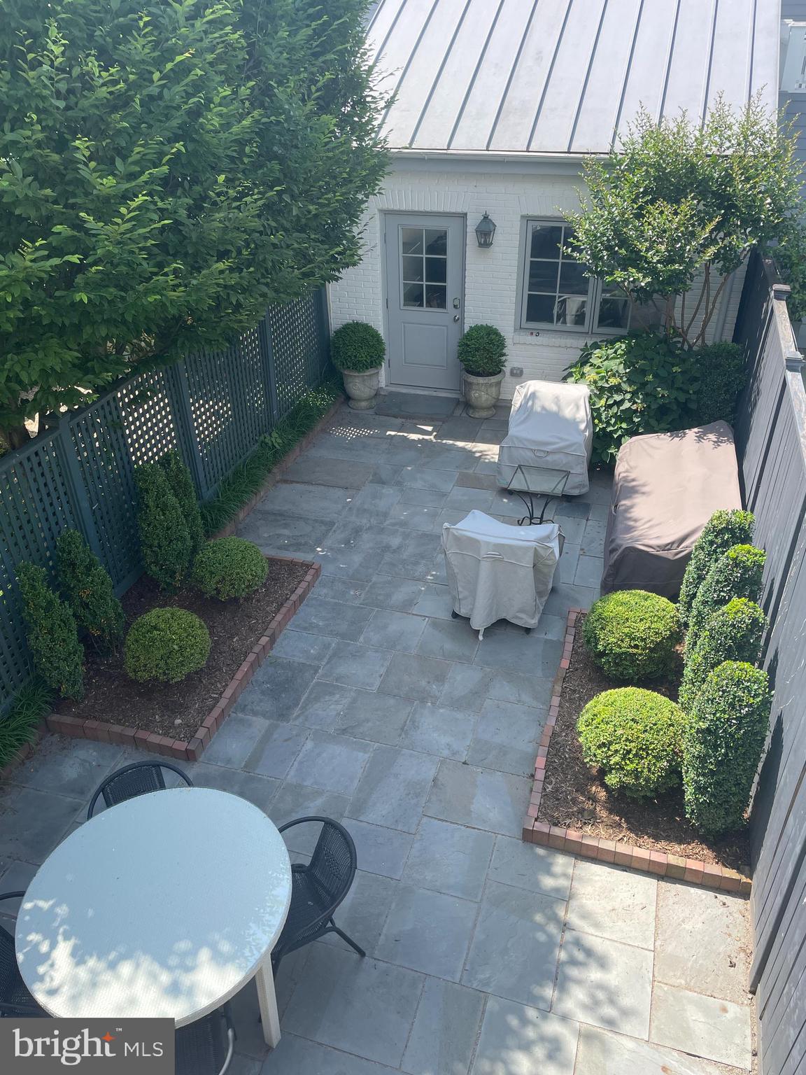 2802 P Street Northwest Washington, DC 20007 - Photo 45 of 58 a view of a backyard with table and chairs potted plants and floor to ceiling window