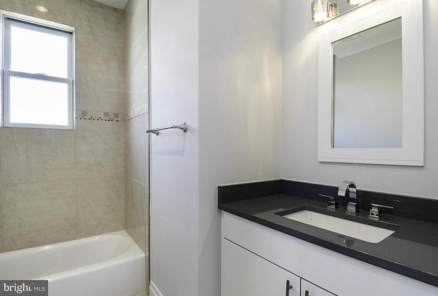 2802 P Street Northwest Washington, DC 20007 - Photo 56 of 58 a bathroom with a granite countertop sink a mirror and a bathtub