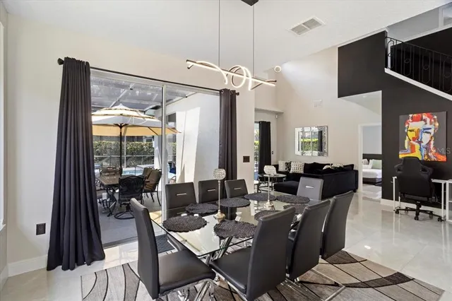 a view of a dining room with furniture one side kitchen view and a chandelier