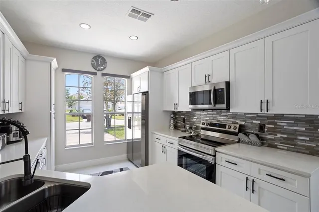 a kitchen with stainless steel appliances a stove sink microwave and cabinets