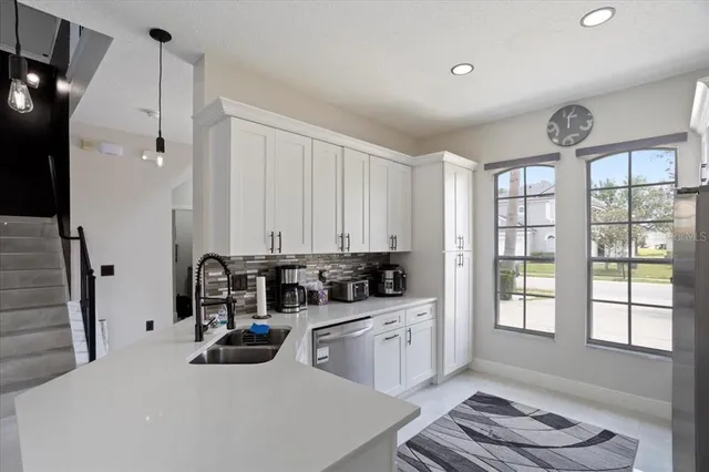 a kitchen with a sink a window and cabinets