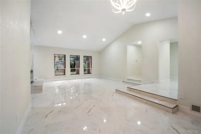 a kitchen with stainless steel appliances a dining table chairs sink and cabinets