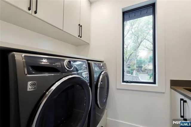 a kitchen with granite countertop a stove a sink a refrigerator and a dining table with wooden floor