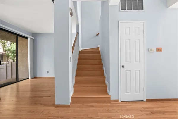 a view of a hallway with wooden floor and staircase