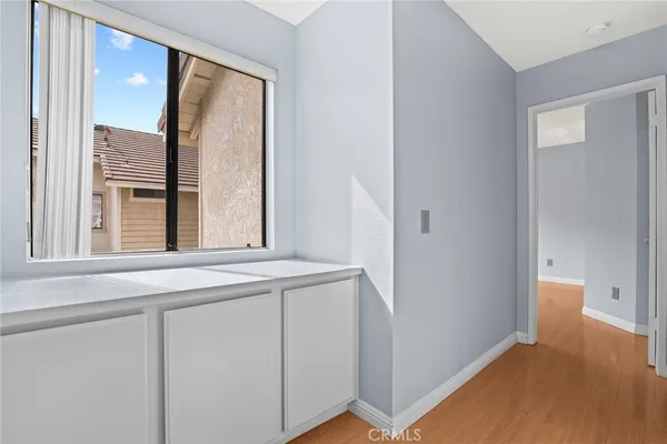 a bedroom with bed couch and three large window