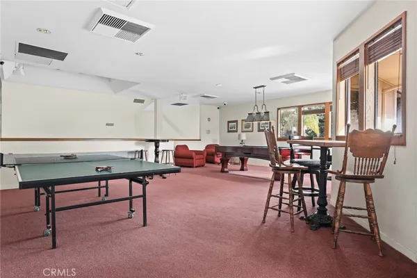 a living room with furniture pool table and windows