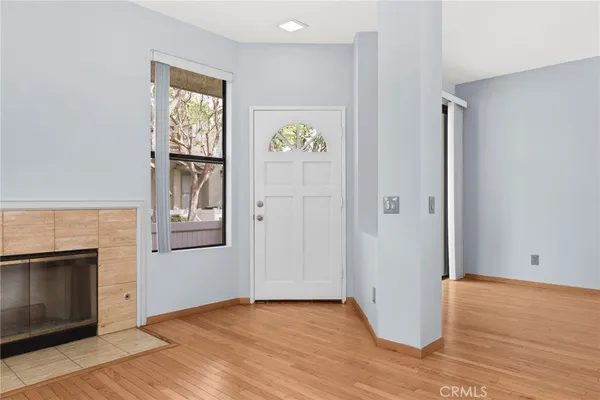 an empty room with windows and fireplace