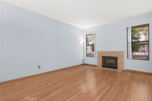 a view of empty room with wooden floor and fireplace