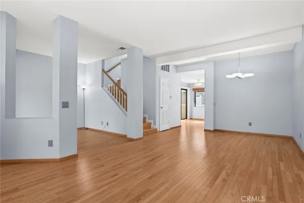 a view of empty room with wooden floor and stairs