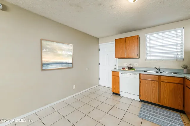 a kitchen with a sink cabinets and a window