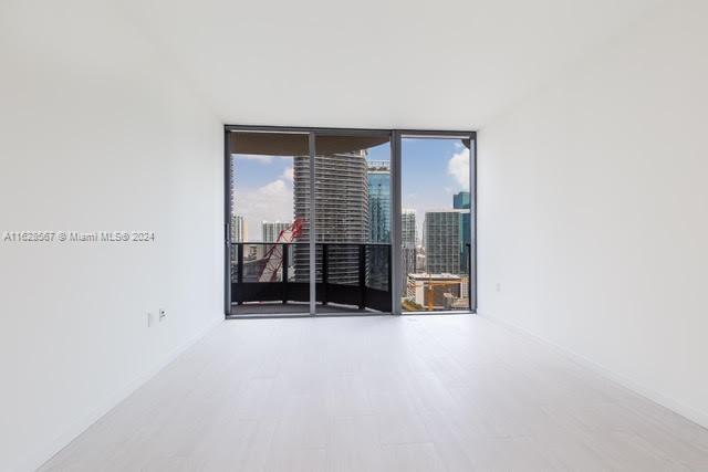 1000 Brickell Plaza, Unit 4015 Miami, FL 33131 - Photo 19 of 29 an empty room with wooden floor and windows