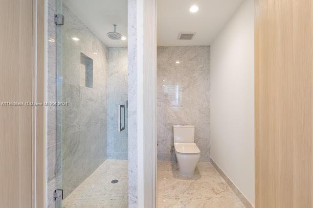 1000 Brickell Plaza, Unit 4015 Miami, FL 33131 - Photo 25 of 29 a bathroom with a granite countertop toilet a sink and shower