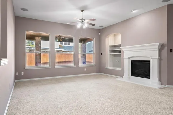 a view of an empty room with a fireplace and a window
