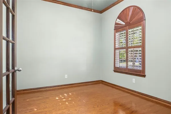 an empty room with chandelier and windows