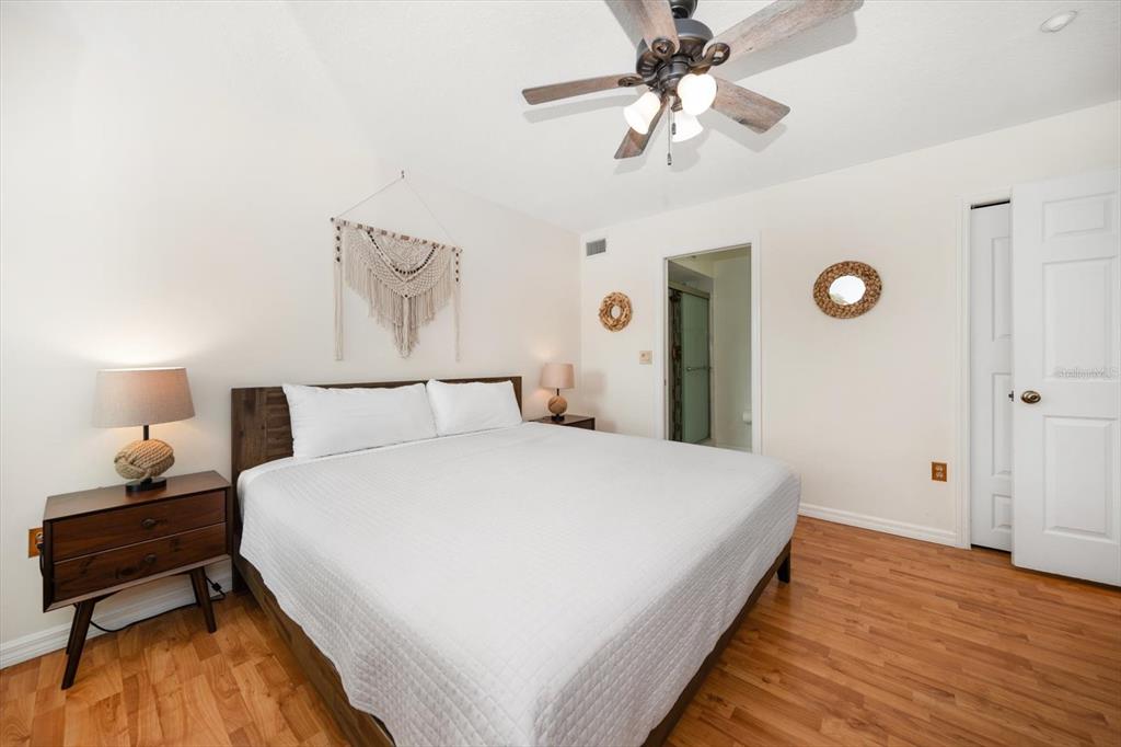 1500 Gulf Boulevard, Unit 103B Indian Rocks Beach, FL 33785 - Photo 15 of 58 a spacious bedroom with a bed and a chandelier
