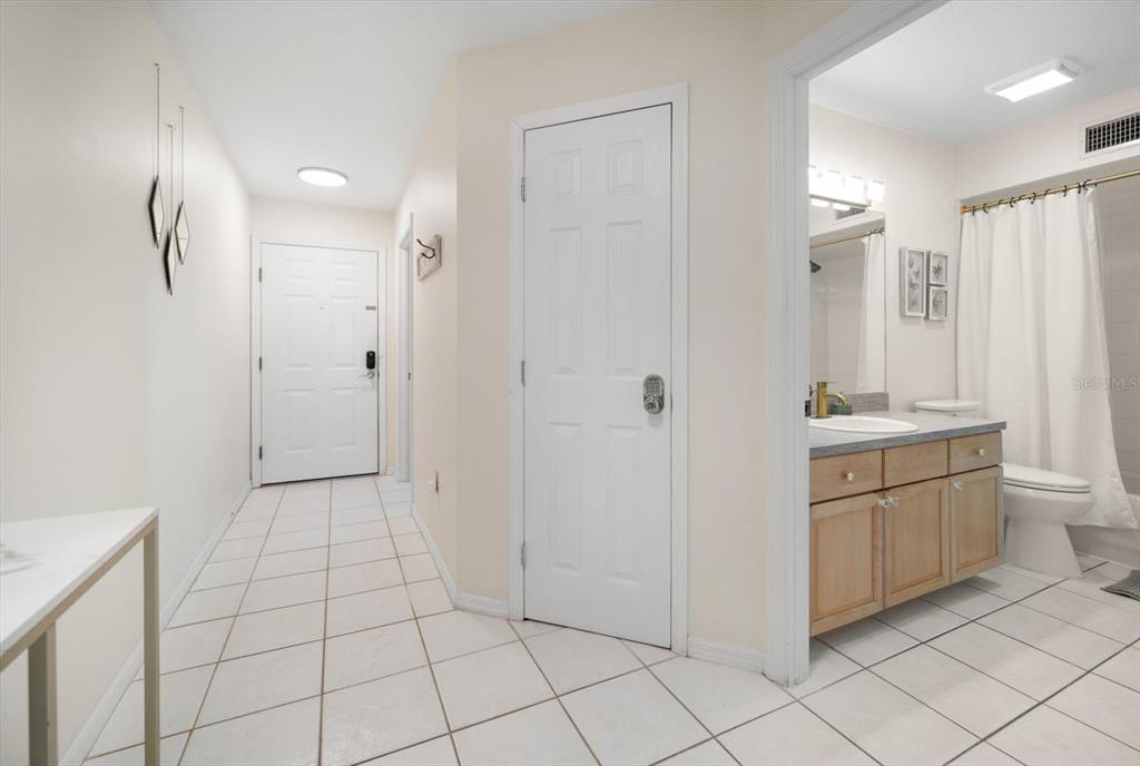 1500 Gulf Boulevard, Unit 103B Indian Rocks Beach, FL 33785 - Photo 25 of 58 a bathroom with a granite countertop sink a mirror and a shower