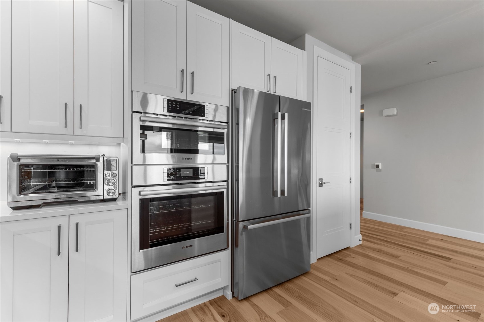 4907 Main Street, Unit 508 Tacoma, WA 98407 - Photo 8 of 40 a kitchen with cabinets stainless steel appliances and wooden floor