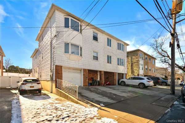 a front view of a building with cars parked
