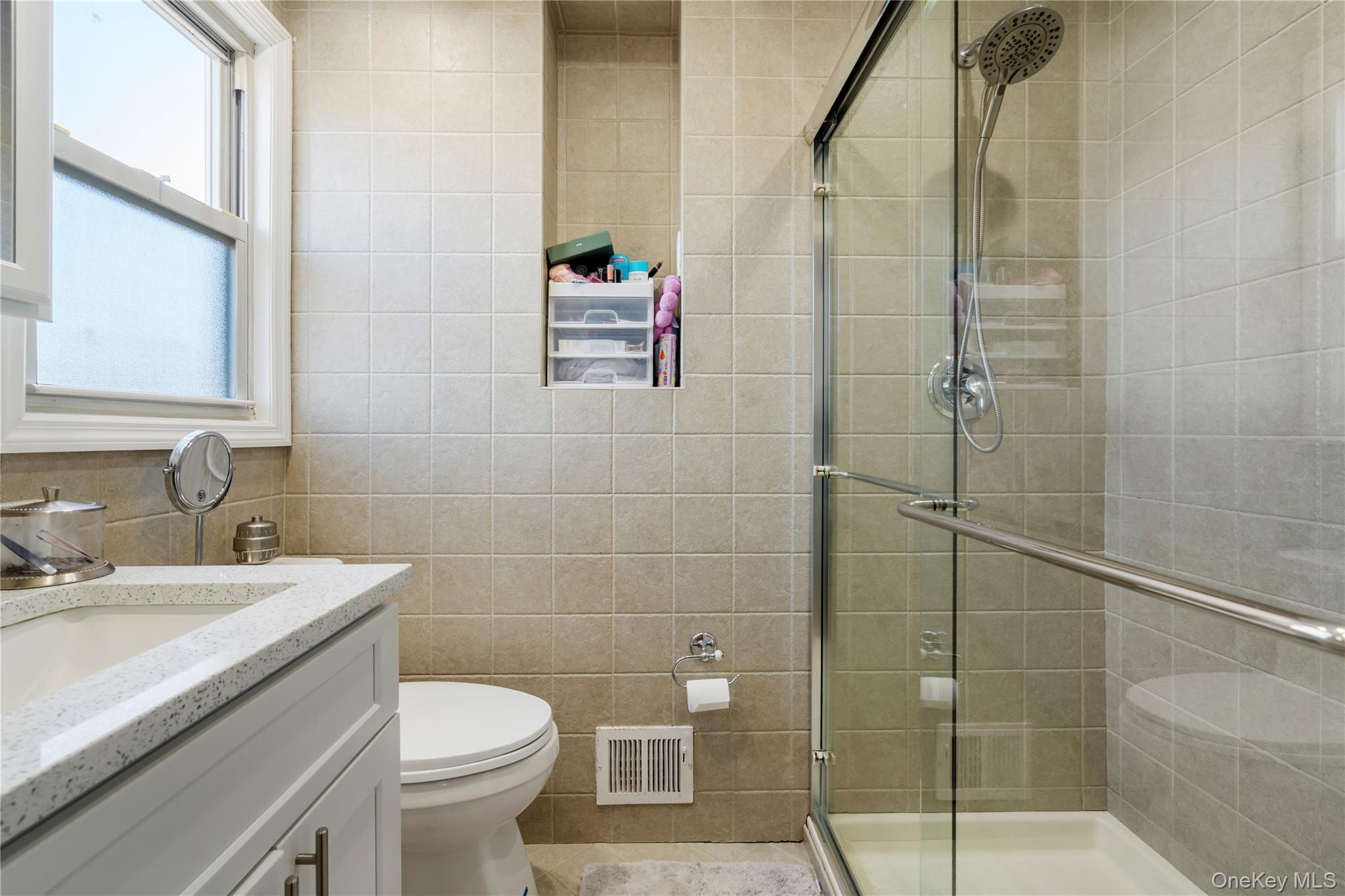 208-48 15th Road, Unit 2 Queens, NY 11360 - Photo 17 of 23 Bathroom featuring vanity, tile walls, and a shower stall